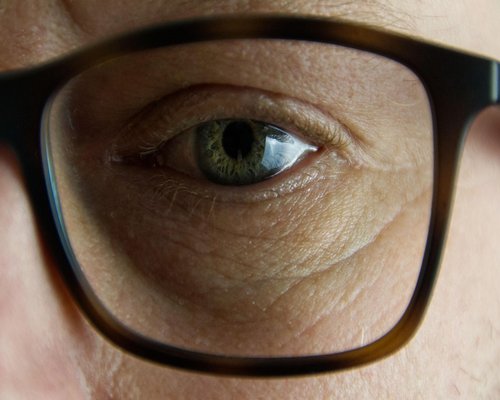 Close up of tired eyes with glasses reflection